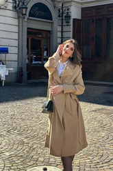 a lady in a brown long trench coat